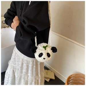 Sac bandoulière panda en crochet fait main porté par un mannequin dans un décor cosy