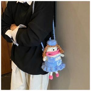 Détail d'un sac bandoulière au crochet fait main avec une robe bleue et des cheveux tressés