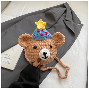 Détail d'un sac bandoulière ours au crochet fait main avec bonnet de fête et étoile