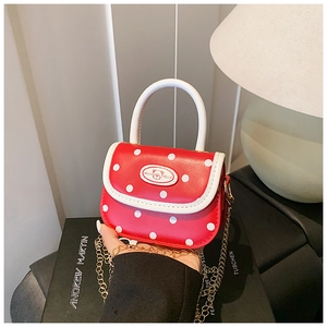 Detail of red polka dot mini bag for girls with white handle and gold chain strap