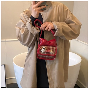 Detailed view of red plaid kids crossbody bag featuring a plush cartoon puppy and large bow