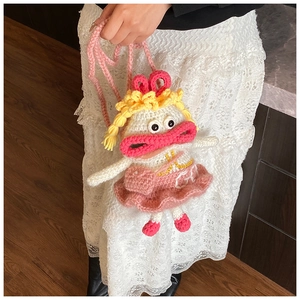 Détail d'un sac bandoulière en crochet fait main avec figurine et texture tricotée