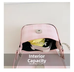 Internal capacity of pink plaid crossbody bag showing a compact interior and metal chain