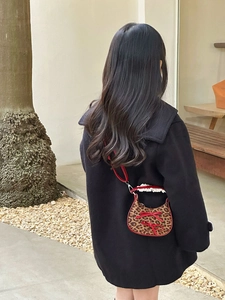 Dettaglio della borsa leopardata con fiocchi di raso rosso e pizzo bianco