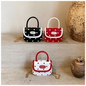 Detailed view of mini polka dot kids purses with cute bear badges and metal chains