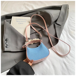 Detail der süßen Mini-Handtasche aus blauem Denim mit rosa Rand und weißem Spitzen-Griff