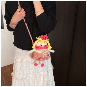 Détail du sac à bandoulière poupée au crochet avec robe en tricot rose et nœud rouge