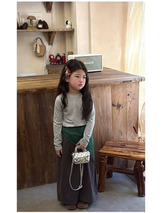 Detail of silver metallic quilted mini bag held by a girl in forest style outfit