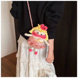 Détail du sac bandoulière poupée crocheté à la main avec robe rose et tresses