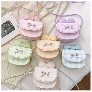 Close-up of checkered mini bags with lace trim and metal butterfly bow detail