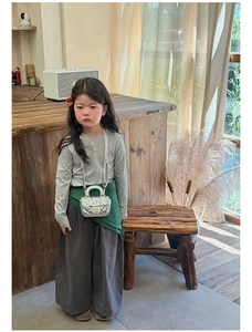 Detail of silver quilted mini bag for girls with golden metal twist lock and chain strap