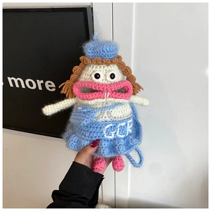 Détail du sac poupée tricoté à la main avec robe bleue et broderie GCR