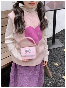Pink checkered kids crossbody bag with lace trim and silver bow detail outdoors