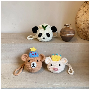 Détail de trois sacs bandoulière animaux crochetés à la main pour enfants sur fond épuré