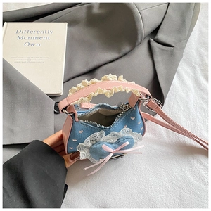 Detail der Mini-Jeans-Handtasche mit rosa Ledergriffen und blauem Herz-Patch