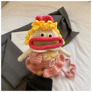 Détail d'un sac bandoulière au crochet fait main avec lèvres roses et nattes jaunes