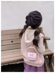 Pink plaid children's shoulder bag with lace trim and silver bow on model
