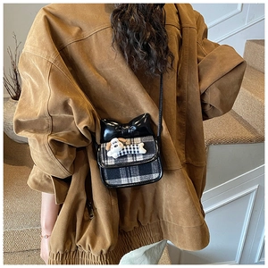 Detail of plaid mini crossbody bag with glossy bow and plush puppy for kids