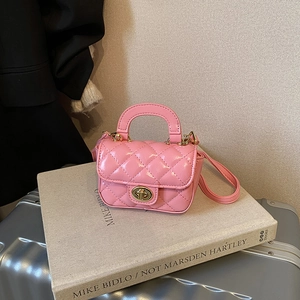 Close-up of pink quilted mini bag with glossy texture and gold rotary buckle