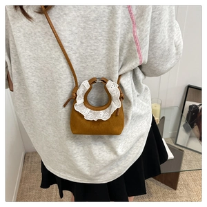 Mini sac en daim marron avec bordure en dentelle blanche et bandoulière sur modèle