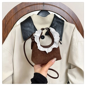 Détail d'un mini sac à main en daim marron avec bordure en dentelle blanche élégante