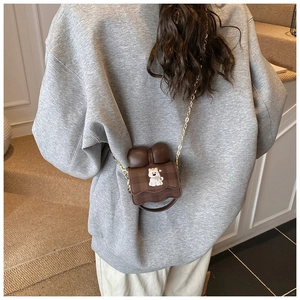 Fille portant un sac à bandoulière marron à carreaux avec nœud et broderie de chiot