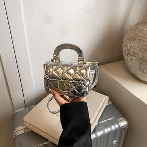 Detail of a silver quilted mini handbag for girls with gold twist-lock and chain strap