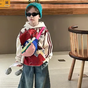 Child streetwear look with tricolor chest bag and cream hoodie on urban fashion model