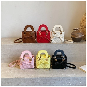 Detailed view of quilted mini bags with bow tie accents in six trendy colors