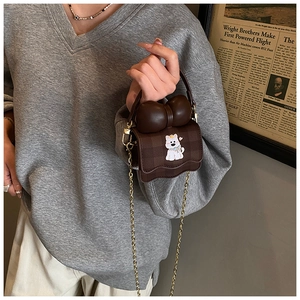 Détail du mini sac à carreaux marron avec écusson de dessin animé et poignée à nœud