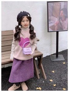 Little girl in purple heart knit vest and skirt with mini bow crossbody bag