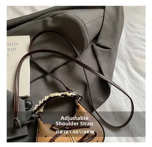 Detail of adjustable strap and lace handles on a brown polka dot bow shoulder bag