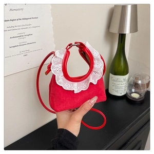 Gros plan du mini sac à main rouge en daim avec dentelle blanche et bandoulière mince