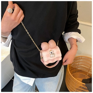 Vue détaillée du sac bandoulière rose à carreaux pour enfant avec patch chien et nœud