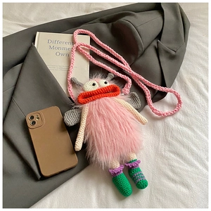 Vue détaillée d'un sac téléphone monstre rose au crochet fait main avec texture peluche