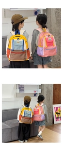 Detail of colorful patchwork children backpacks featuring multiple storage pockets and straps