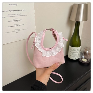 Détail du mini sac à main en daim rose avec broderie de dentelle blanche délicate