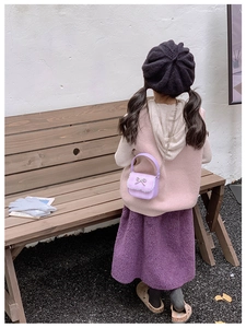Close-up of girls purple bow shoulder bag with lace trim and rhinestone buckle