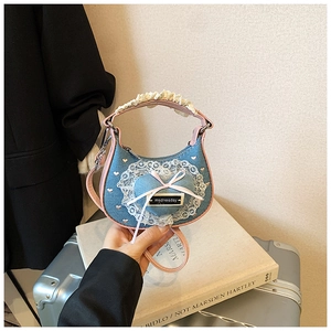 Detailansicht der Jeans-Herzhandtasche mit Spitzenbesatz und rosa Ledergriff für Mädchen