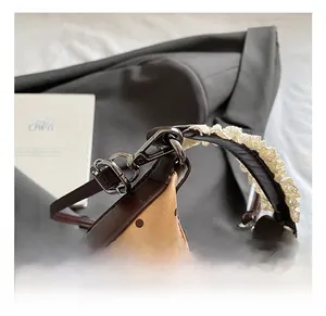Macro detail of brown polka dot leather mini bag with metal hook and lace handle trim