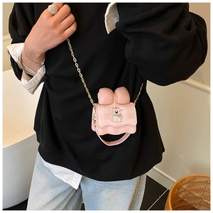 Détail du mini sac bandoulière à carreaux rose avec grand nœud et chaîne dorée