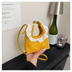 Vue détaillée d'un mini sac à main en daim jaune gingembre avec bordure en dentelle blanche