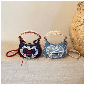 Detailansicht von Denim-Taschen mit Spitzenbesatz, Herz-Stickerei und Wednesday-Label