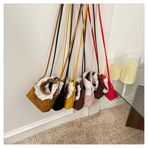 Détail de mini sacs bandoulière en daim avec bordure en dentelle blanche en sept couleurs