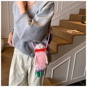 Détail du sac à téléphone monstre rose avec yeux au crochet et lèvres rouges