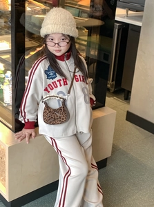 Dettaglio di borsa leopardata per bambina con pizzo delicato e fiocco decorativo