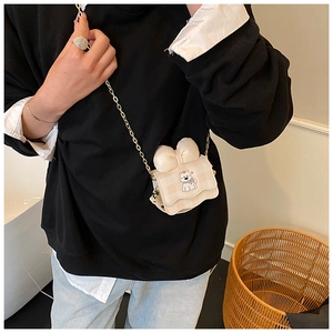 Détail du sac bandoulière enfant à carreaux avec nœud 3D et broderie chiot