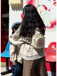 Détail de la broderie lapin rose sur un petit sac à dos en toile crème pour enfant