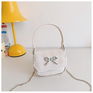 Close-up of cream plaid mini bag with white lace trim and silver bow metallic clasp