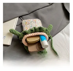 Détail montrant la capacité interne du sac grenouille crocheté avec téléphone et maquillage